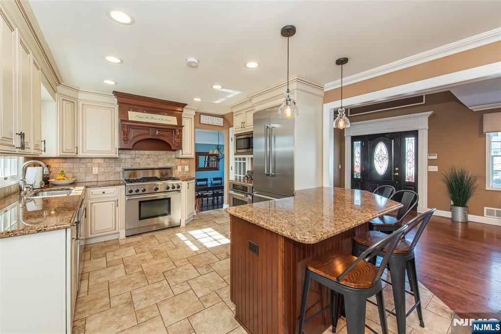 18 Stonycroft Road Wayne, NJ 07470 - Photo 4 of 40 a kitchen with stainless steel appliances a stove a sink a table and chairs