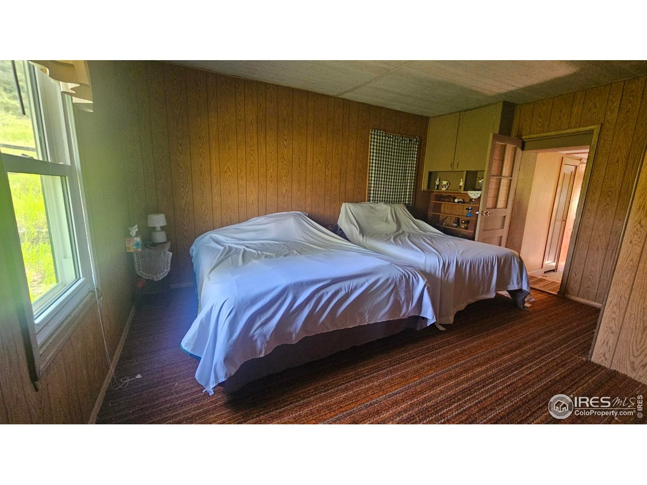 1364 Redbluff Road Livermore, CO 80536 - Photo 19 of 26 a bedroom with a bed lamp and a window