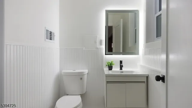 a bathroom with a toilet sink and mirror