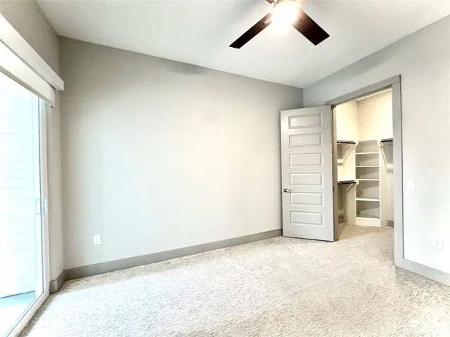 an empty room with closet and chandelier fan