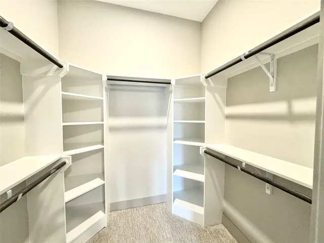 a view of walk in closet with empty racks