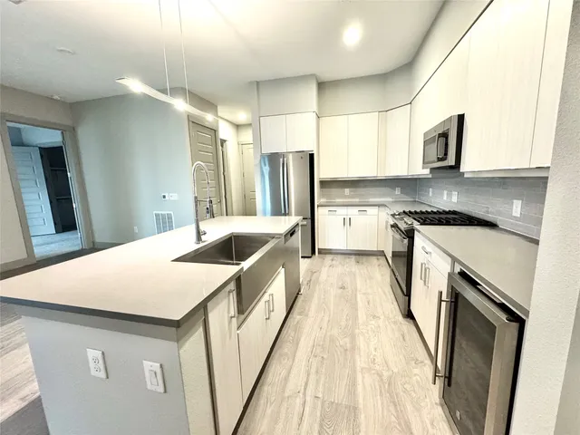 a kitchen with kitchen island granite countertop a stove a sink and a microwave