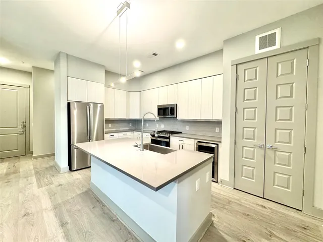a kitchen with stainless steel appliances a refrigerator sink and cabinets