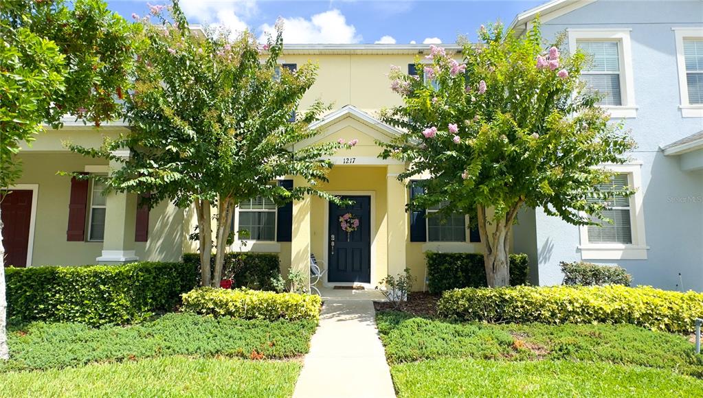 a view of a white house with a clock and a tree