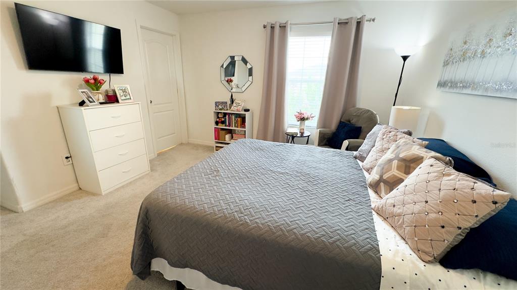 1217 Seburn Road Apopka, FL 32703 - Photo 30 of 61 a bedroom with a bed and flat tv screen on the dresser