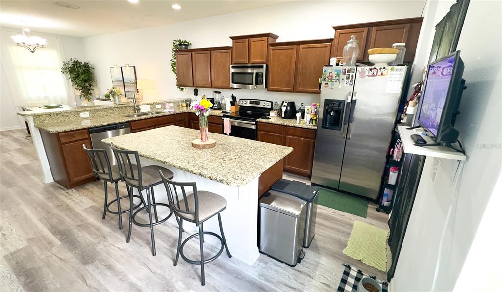 1217 Seburn Road Apopka, FL 32703 - Photo 41 of 61 a kitchen with stainless steel appliances granite countertop a refrigerator a stove top oven a sink and dishwasher