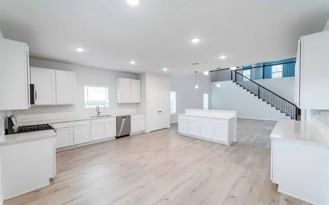 a kitchen with a sink and wooden floor
