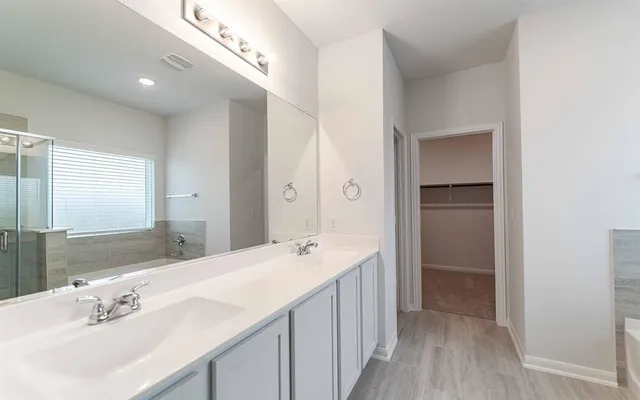 a spacious bathroom with a sink and mirror