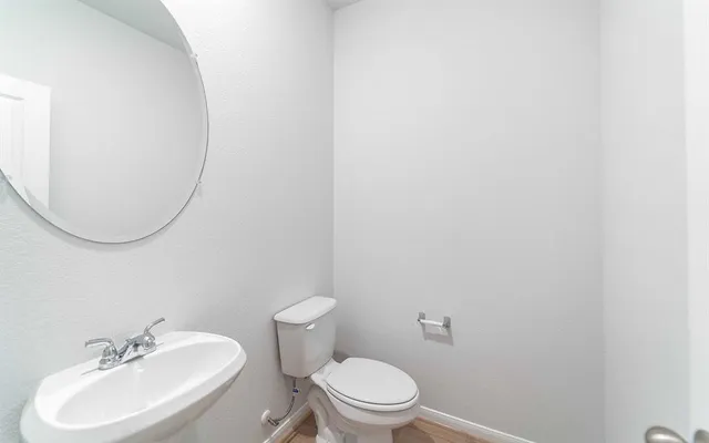 a bathroom with a sink a toilet and a mirror