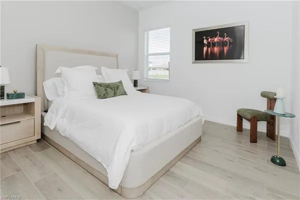 a bedroom with a bed and a painting on the wall