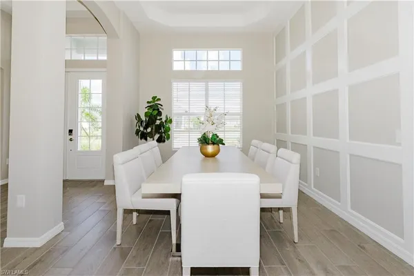 a dining room with furniture potted plants and wooden floor