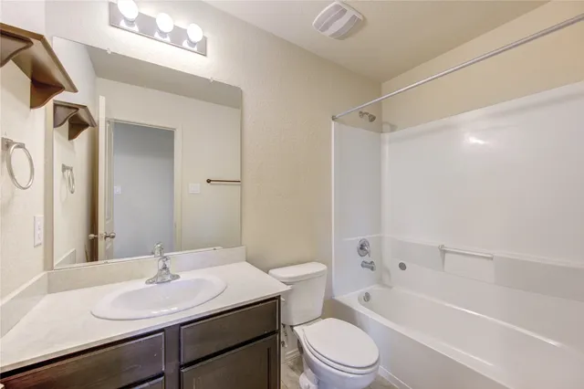 a bathroom with a sink toilet vanity and shower