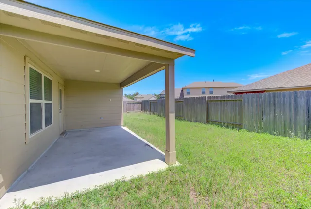a view of backyard with wooden fence