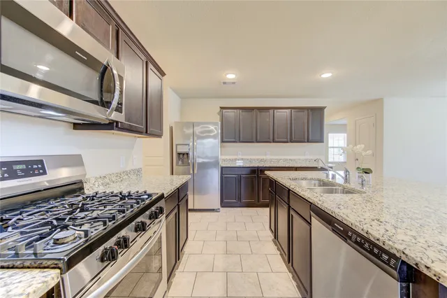 a kitchen with stainless steel appliances granite countertop a sink stove and cabinets
