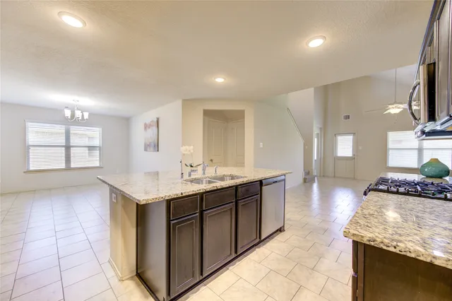 a large kitchen with stainless steel appliances granite countertop a sink and cabinets
