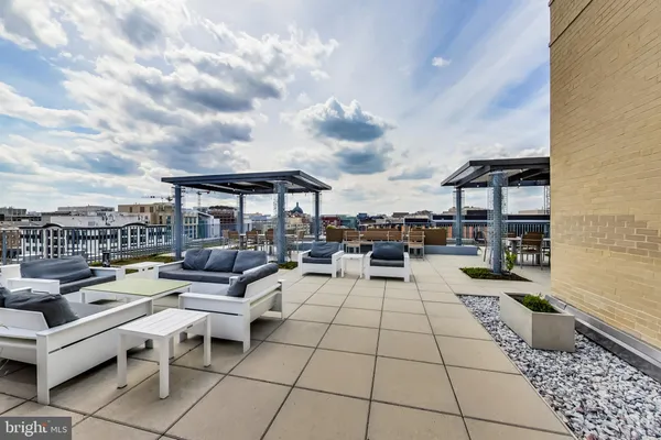a living room with patio furniture and a rug