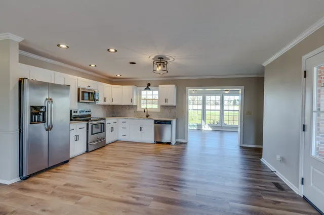 a kitchen with granite countertop a stove a sink and a refrigerator