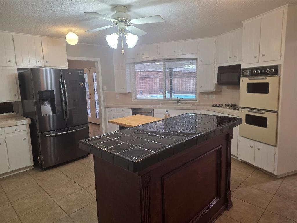 Undisclosed Address Hurst, TX 76054 - Photo 7 of 29 BREAKFAST EATING AREA ADJACENT TO ISLAND, GAS COOKTOP, SERVING WINDOW