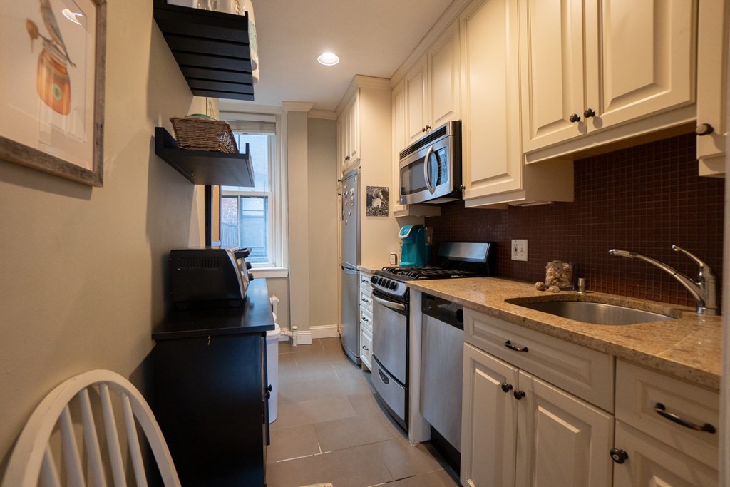 11 Irving Street, Unit 6 Boston, MA 02114 - Photo 7 of 14 a kitchen with stainless steel appliances granite countertop a refrigerator and a sink