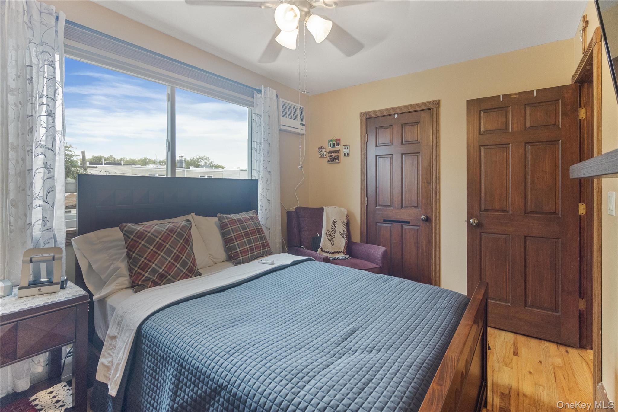 69-24 68th Place Queens, NY 11385 - Photo 15 of 26 a bedroom with a large bed and a chandelier