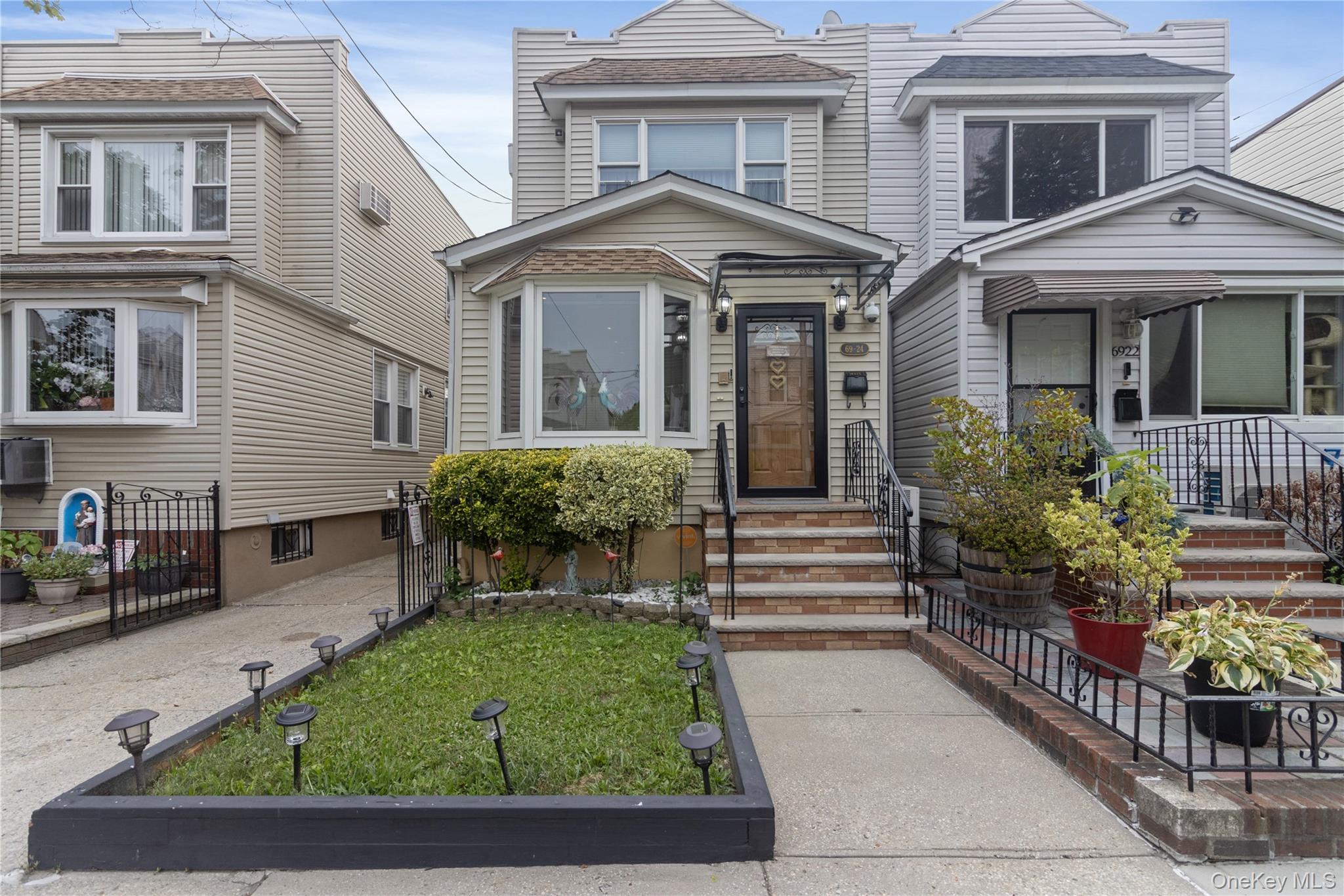69-24 68th Place Queens, NY 11385 - Photo 2 of 26 front view of a house with a yard