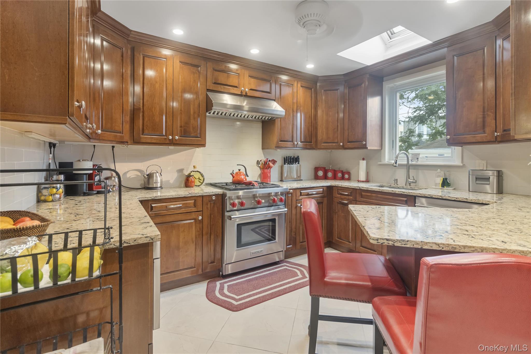 69-24 68th Place Queens, NY 11385 - Photo 10 of 26 a kitchen with stainless steel appliances granite countertop a sink a stove a refrigerator cabinets and a dining table