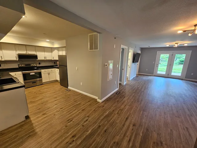 a view of kitchen with microwave a stove and wooden floor