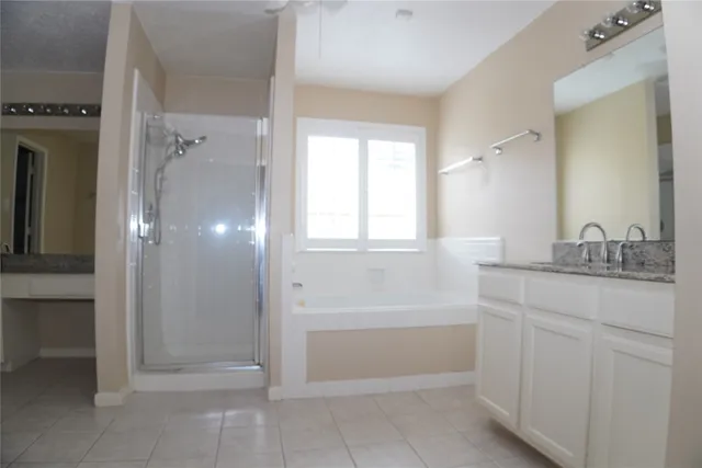 a bathroom with a granite countertop sink a mirror and a bathtub