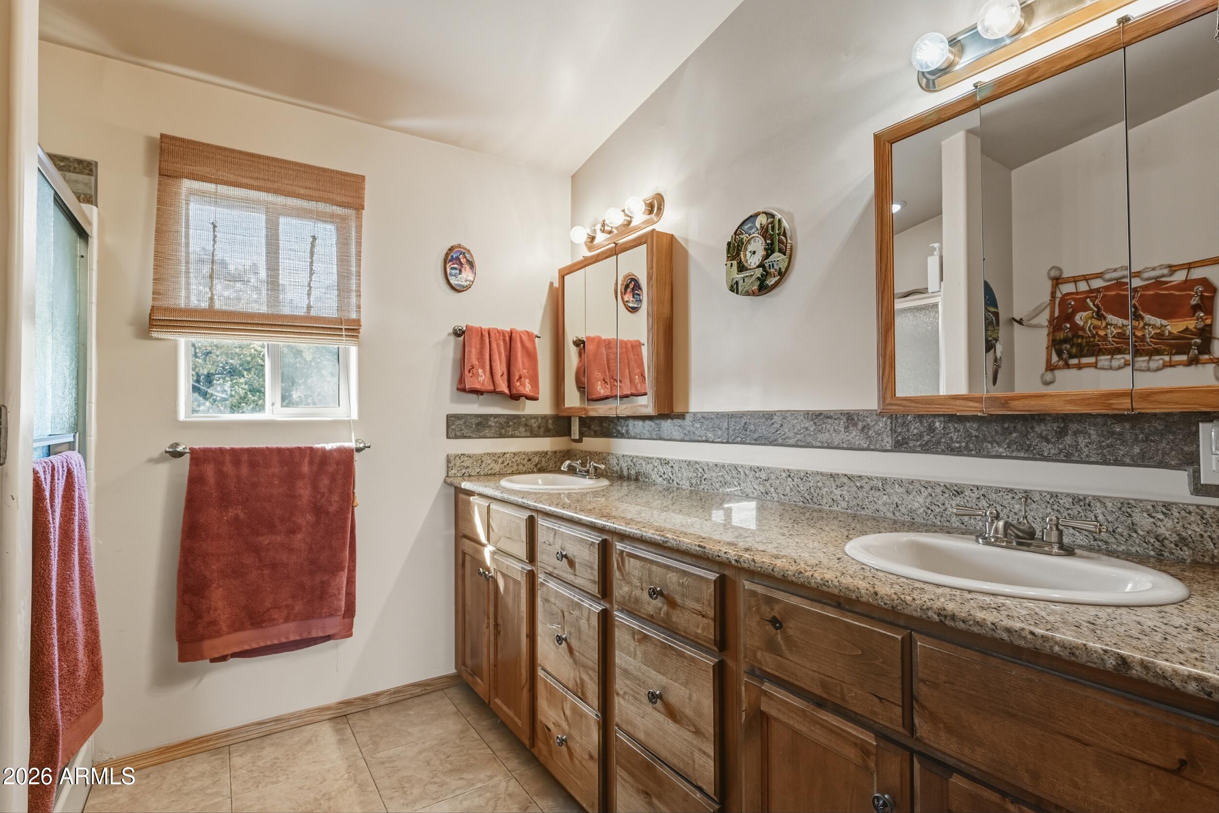 3119 Kysar Way Pine, AZ 85544 - Photo 24 of 68 a bathroom with a granite countertop double vanity sink and a window