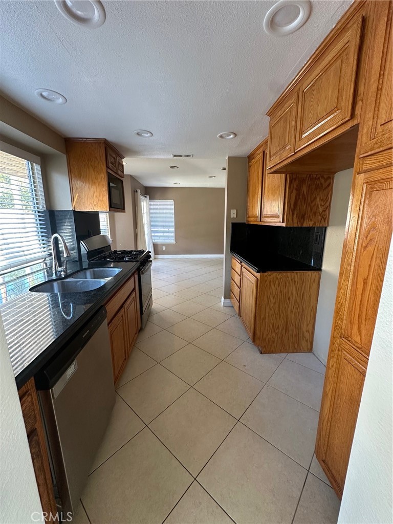 13470 Mallorca Lane Chino Hills, CA 91709 - Photo 17 of 44 a kitchen with stainless steel appliances a sink stove and cabinets