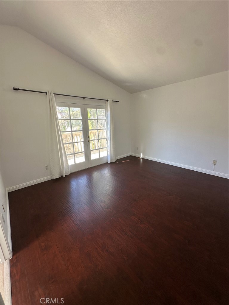 13470 Mallorca Lane Chino Hills, CA 91709 - Photo 26 of 44 an empty room with wooden floor and windows with curtains