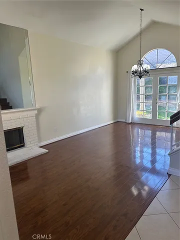 an empty room with wooden floor and fireplace