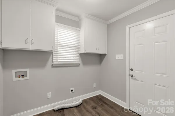 an empty room with wooden floor and cabinet