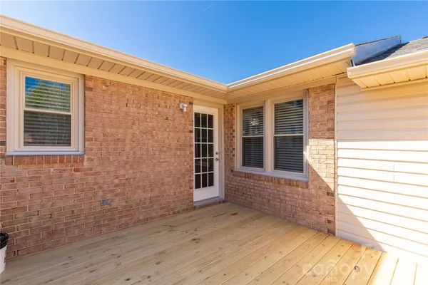 a view of a porch with wooden floor and a window