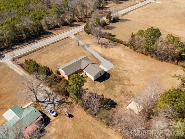 an aerial view of a house with a yard and mountain view in back
