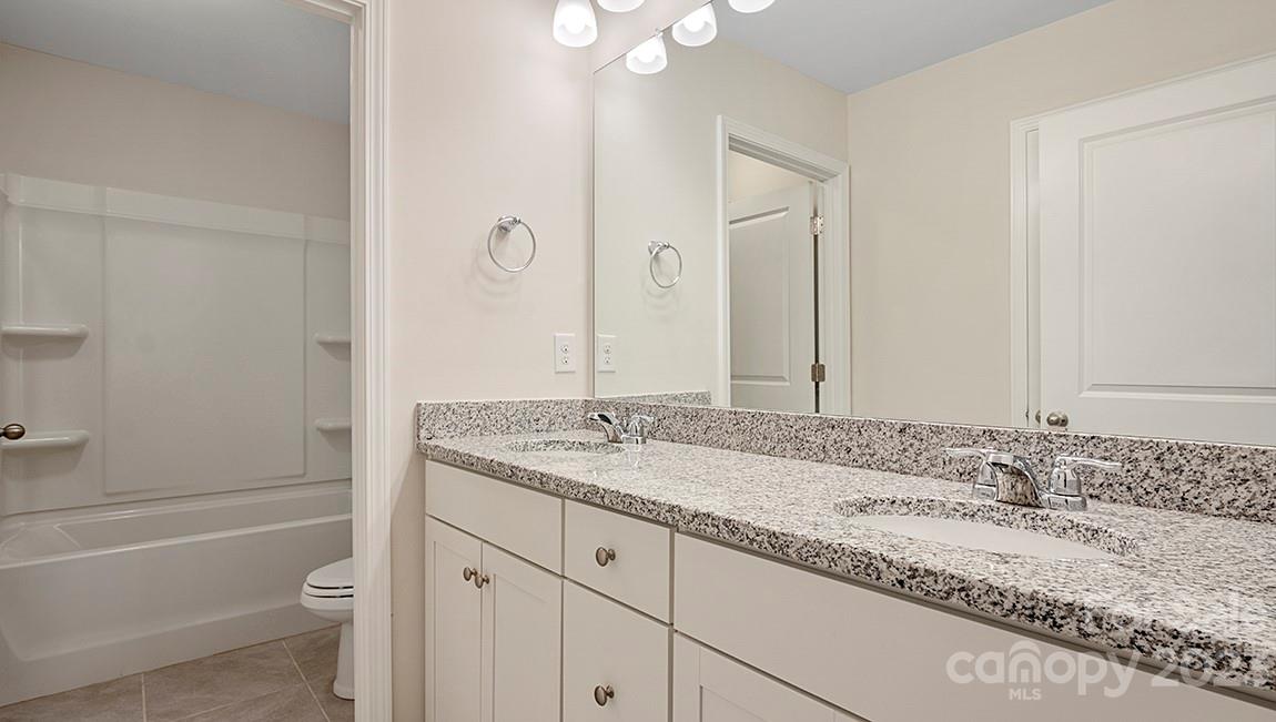 149 Fox Cove Road Hendersonville, NC 28792 - Photo 22 of 34 a bathroom with a granite countertop sink toilet and shower