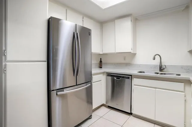 a kitchen with a refrigerator sink and cabinets