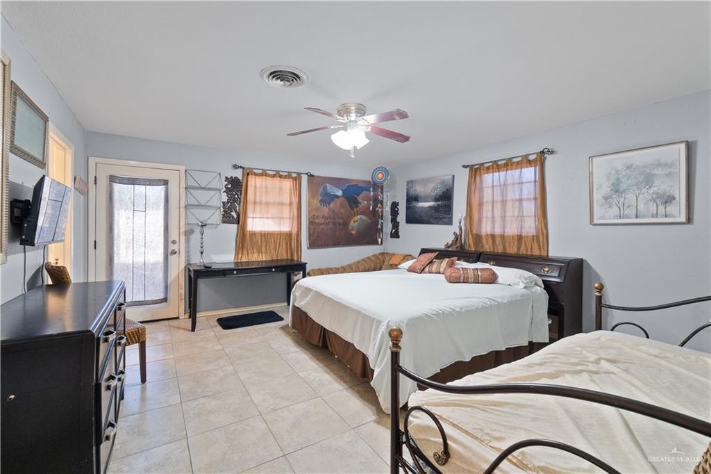 313 North 40th Street McAllen, TX 78501 - Photo 16 of 27 a spacious bedroom with two beds and a chandelier