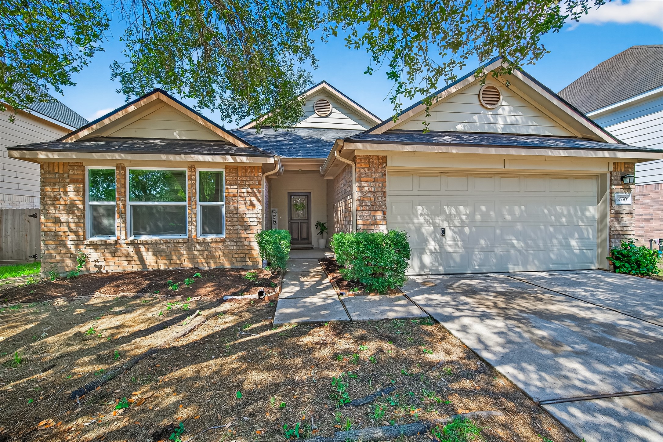 a front view of a house with a yard and potted plants