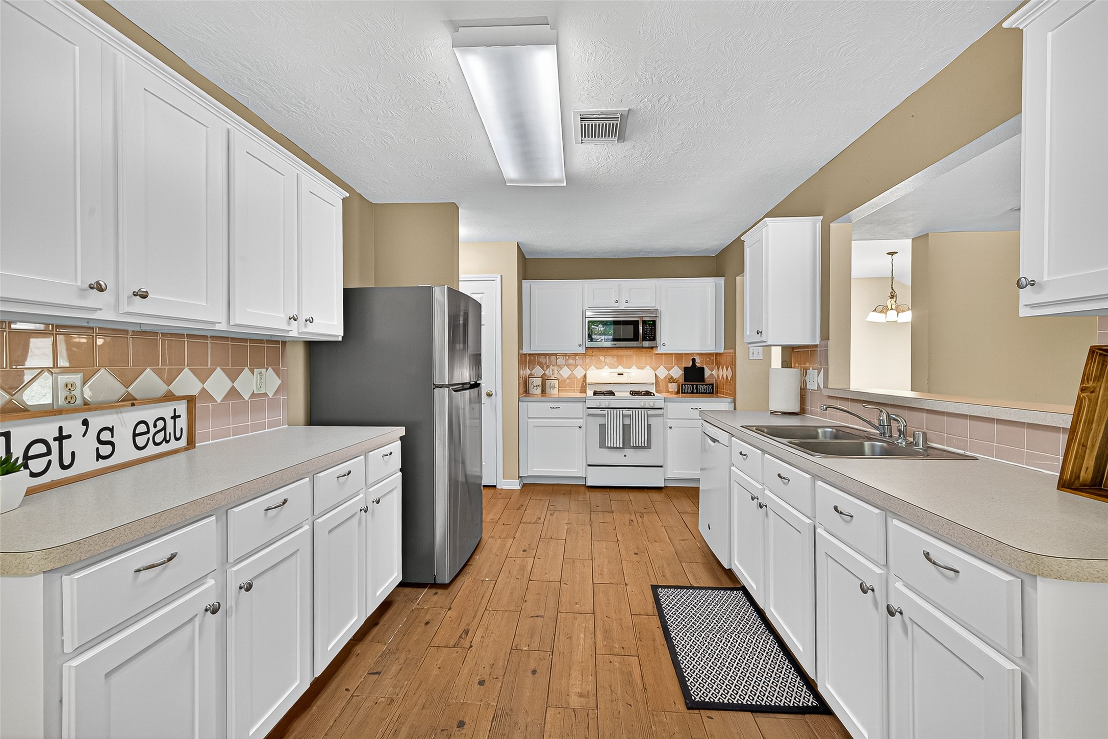 4630 Twisting Road Houston, TX 77084 - Photo 21 of 49 a kitchen with white cabinets sink and refrigerator