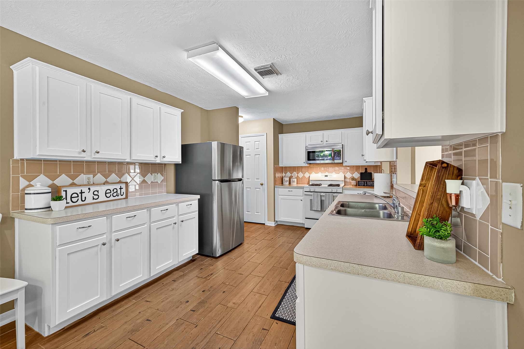 4630 Twisting Road Houston, TX 77084 - Photo 22 of 49 a kitchen with refrigerator a stove a sink and cabinets