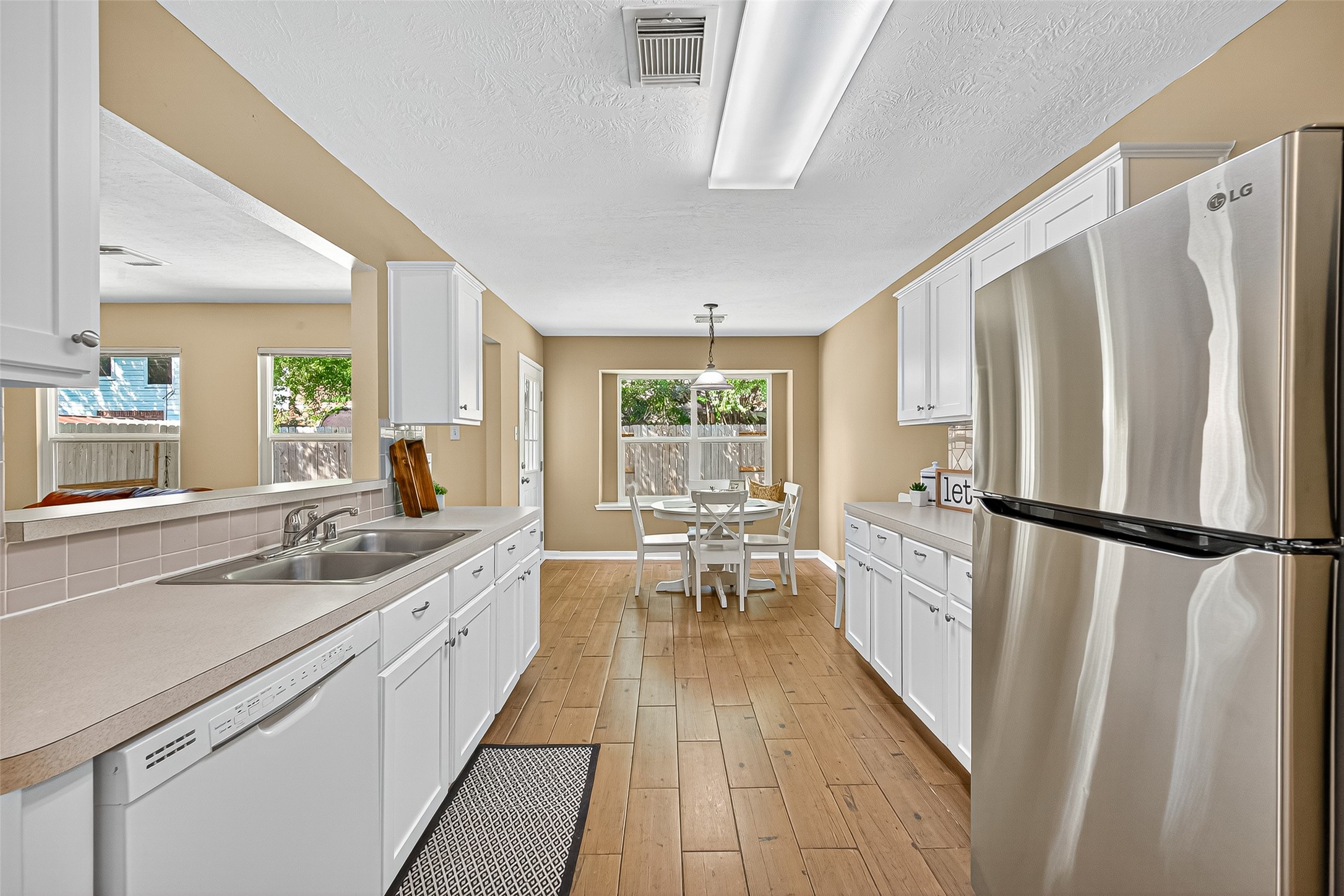 4630 Twisting Road Houston, TX 77084 - Photo 30 of 49 a kitchen with a refrigerator a sink and dishwasher with wooden floor