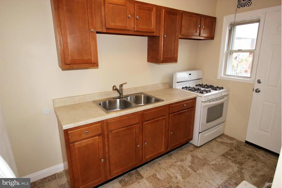 316 Stemmers Run Road Baltimore, MD 21221 - Photo 3 of 20 a kitchen with a sink stove and cabinets