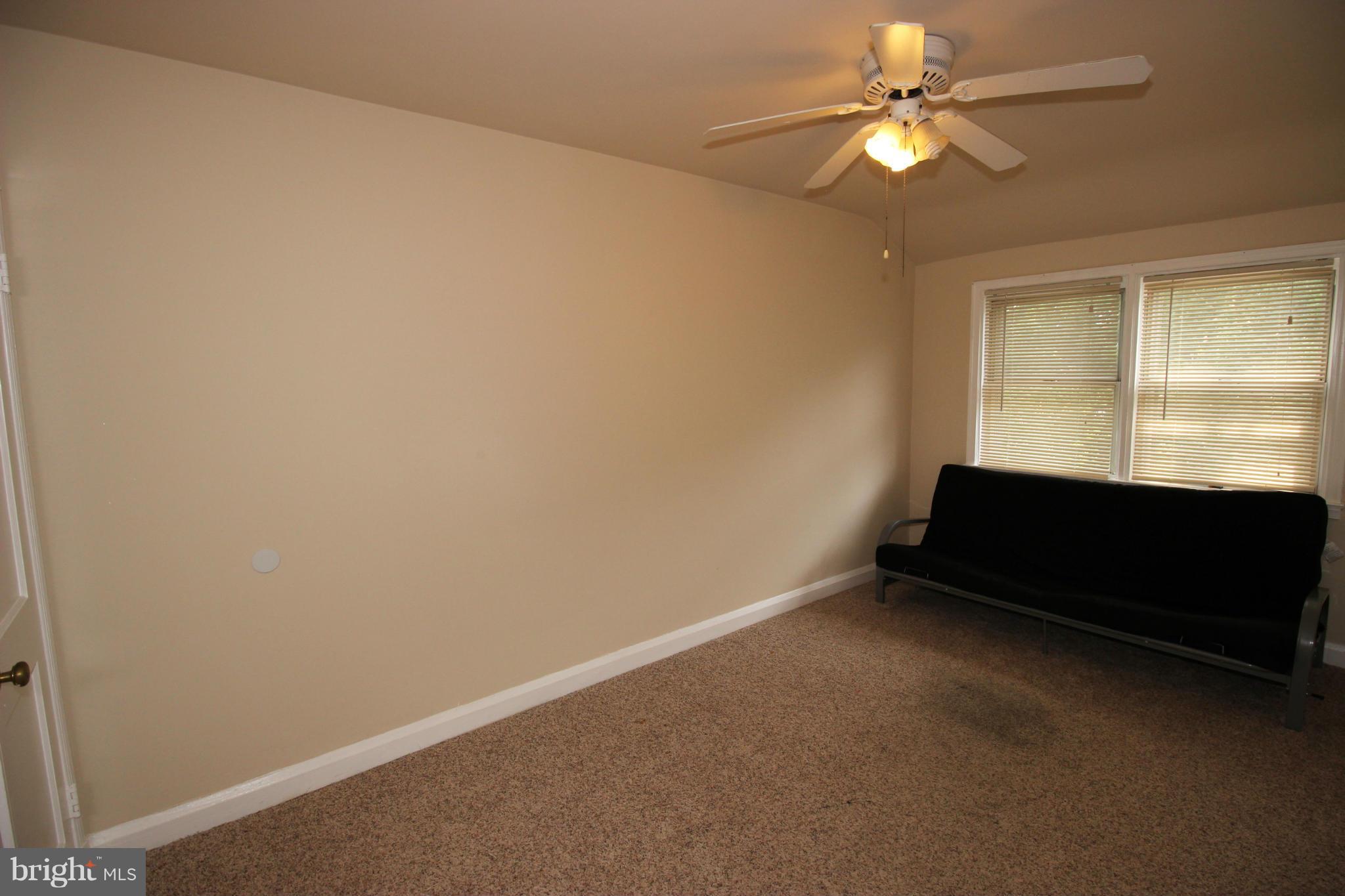 316 Stemmers Run Road Baltimore, MD 21221 - Photo 5 of 20 an empty room with ceiling fan and a window