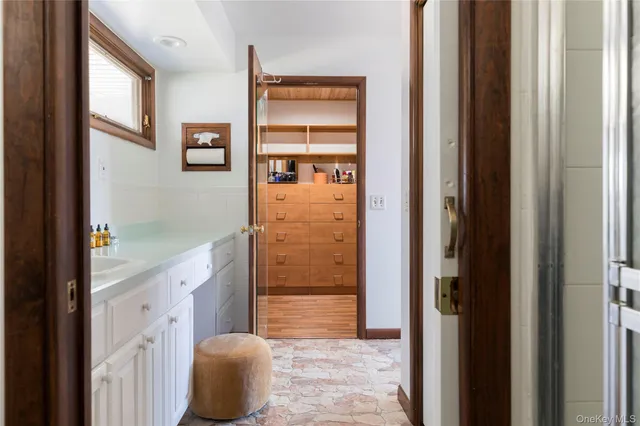 a bathroom with a tub shower sink and mirror