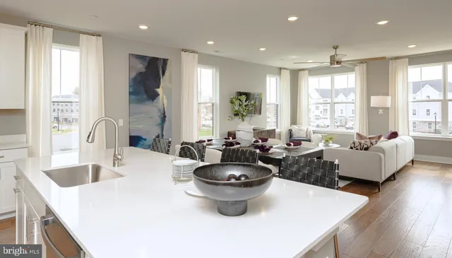 a large white kitchen with sink a large window and a counter space