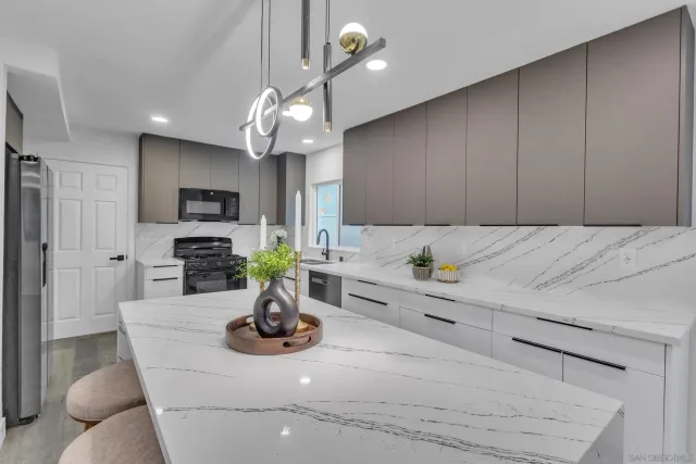 a kitchen with kitchen island granite countertop a sink cabinets and stainless steel appliances