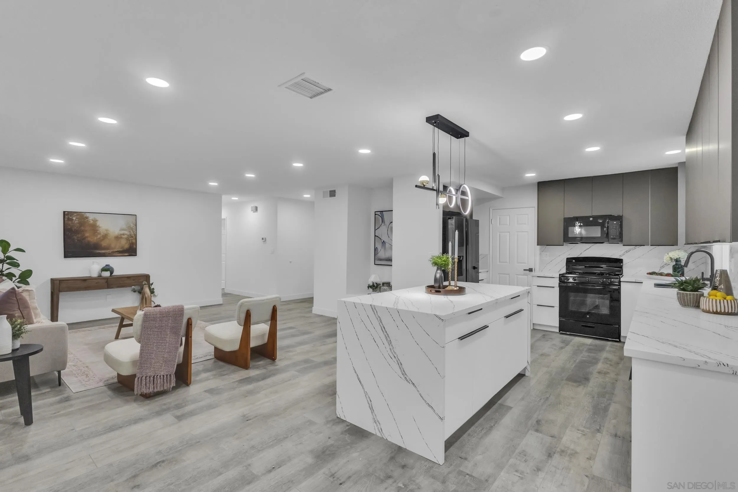 9253 Les Road Santee, CA 92071 - Photo 18 of 35 a large white kitchen with a sink and living room view