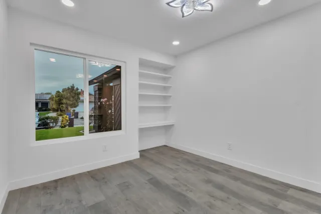 an empty room with windows and fan