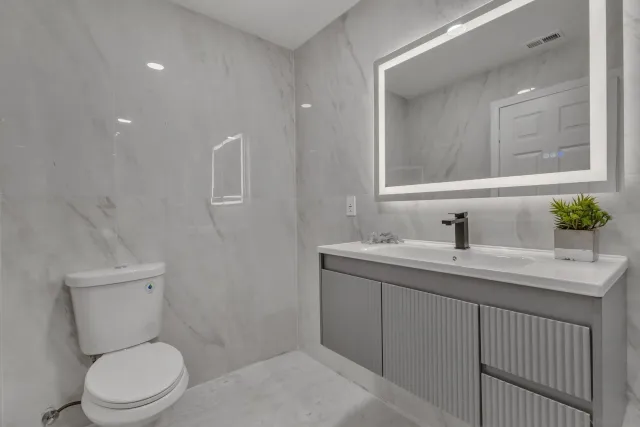 a bathroom with a bathtub shower sink and mirror